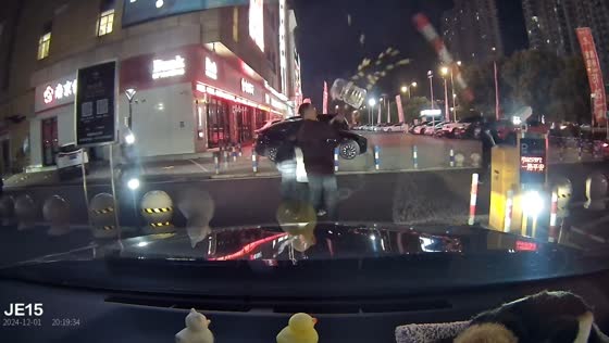  Three individuals surprised by car park barrier while crossing street in Jiangsu, China