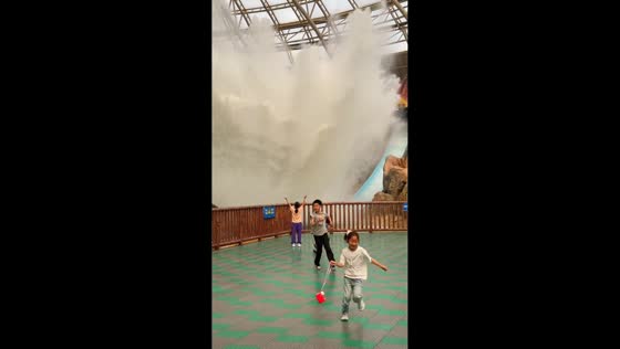 Girl stands still for water splash at amusement park in Tianjin, China