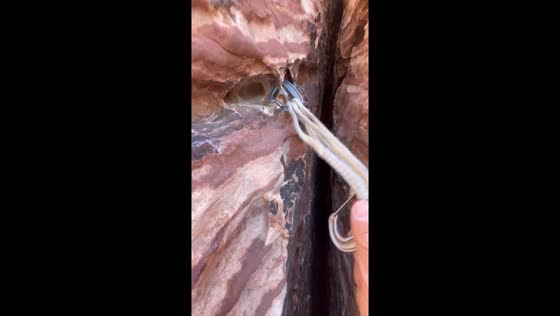 Rock climber clips carabiner on unusual rock hole in Las Vegas expedition