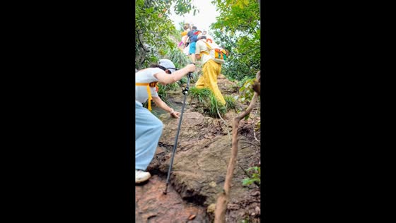 odWoman slips while climbing rocky hiking trail in Zhejiang, China
