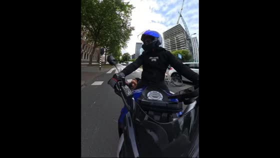 Woman on bicycle falls after crossing red light in front of motorcycle in Rotterdam, Netherlands