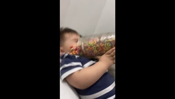 Little boy spills cereal on himself while eating in bed in San Juan, Argentina