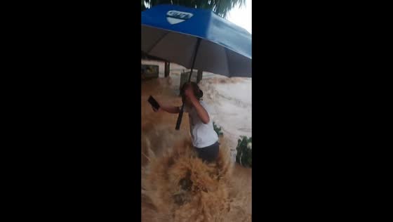 Neighborhood leader slips into flooded hole during heavy rain in Bogor, Indonesia