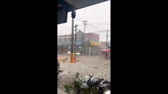 Hail falls into flooded street during storm in Hebei, China