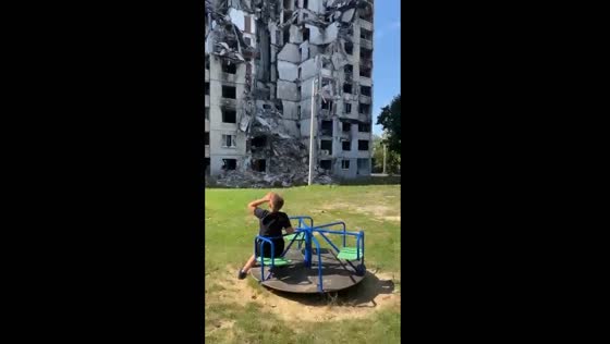 Ukrainian child's roundabout play amidst ruins: a harrowing portrait of conflict's toll