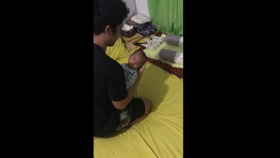 Father's tender efforts: baby's sleep interrupted by a sneezing surprise