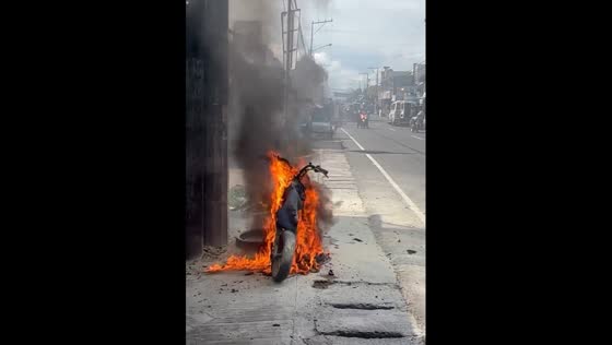 A motorcycle starts a massive fire on the side of the road!