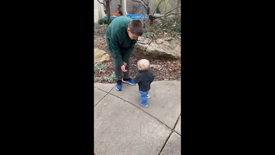 Toddler excitedly runs toward parent at Mesker Zoo in Evansville, Indiana, USA