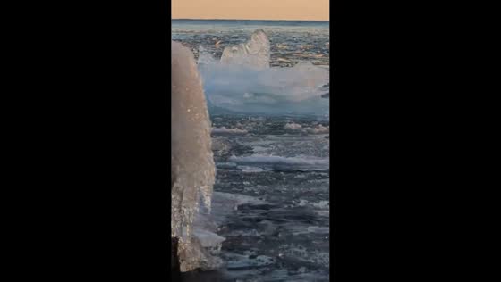 Sunset reflects off drifting ice floes on Lake Superior in Lutsen, Minnesota, USA