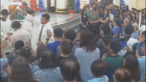 Priest accidentally splashes a large amount of holy water on a person in Manila, Philippines