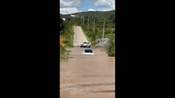 Tesla slowly crosses deep floodwaters on rural road in Yunnan, China