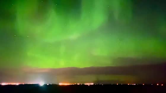 Green Aurora Borealis illuminates Carseland, Alberta's night sky