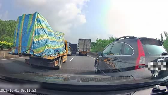 Black car collides with a truck while changing lanes on a highway in Guangdong, China