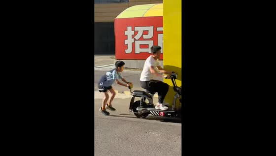 Man on e-bike crashes into container while distracted in Tianjin, China