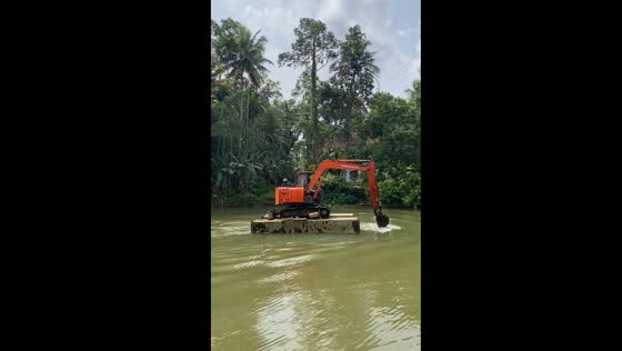 Excavator rows across water using arm as propulsion in Kottayam, India