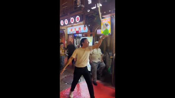Performer accidentally splashes spectator during food stall act in Xinjiang, China