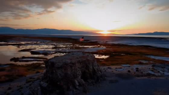 Drone captures American flag atop Black Rock near Great Salt Lake in Utah, USA