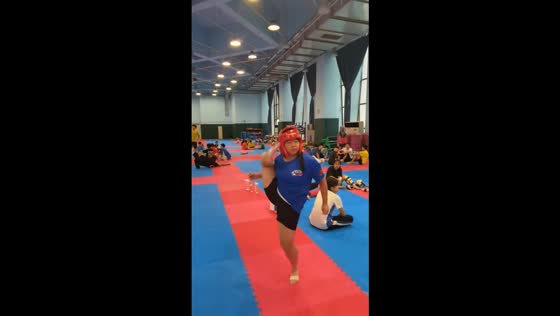 Woman tests helmet durability with fexible side kick in Guangdong, China
