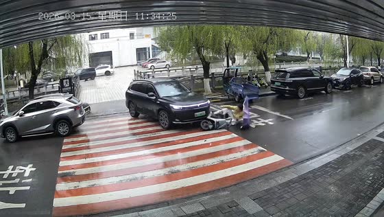 Electric scooter slides toward SUV on rainy road in Hubei, China
