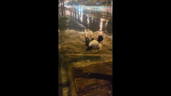 Man slips and falls on flooded wooden sidewalk in Neimenggu, China