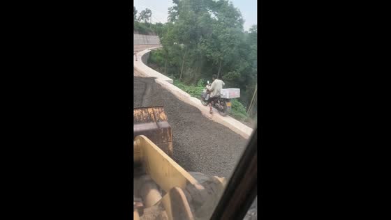 Motorcycle rider loses balance and falls while riding along retaining wall in Henan, China