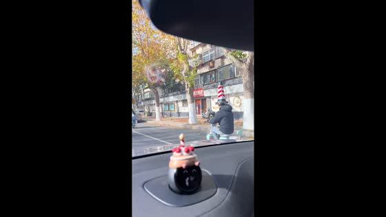 Man rides scooter wearing giant traffic cone as a hat in Shandong, China
