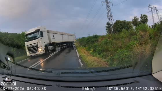 Driver narrowly avoids oncoming semi-truck on wet road in Brăila, Romania