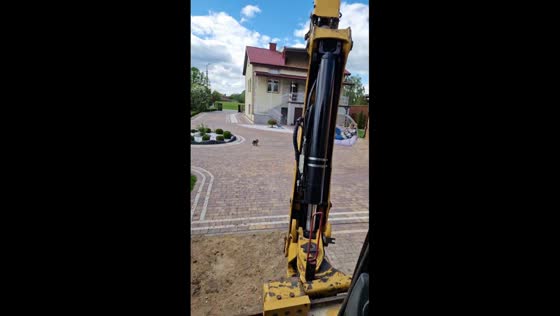 Girl swings in egg chair lifted by backhoe loader in Radzymin, Poland