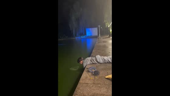 Boy catches fish with dip net in Chongqing, China