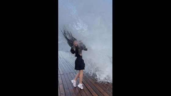 Surprise splash: girlfriend gets soaked by unexpected wave 