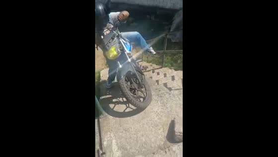 Motorcyclist falls back while attempting to climb stairs in Cali, Colombia