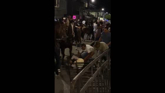 Person falls from horse after losing balance and toppling metal guard rail
