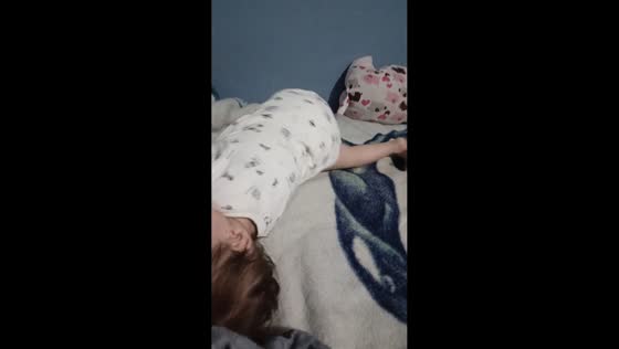 Toddler playfully interrupts sister relaxing on bed in Quito, Ecuador