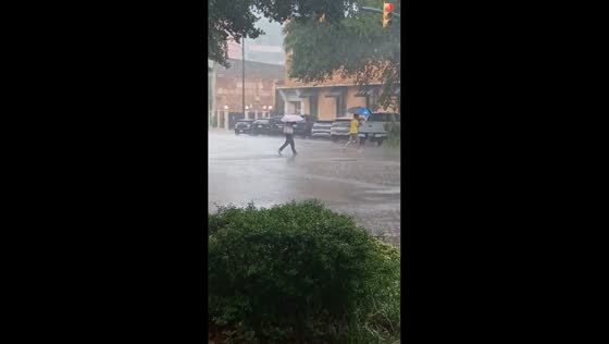 Heavy downpour sends pedestrians through flooded streets in South Carolina, USA