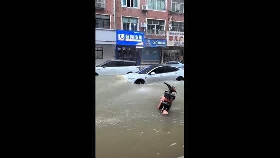 Tesla pushes through deep floodwater on submerged street in Fujian, China