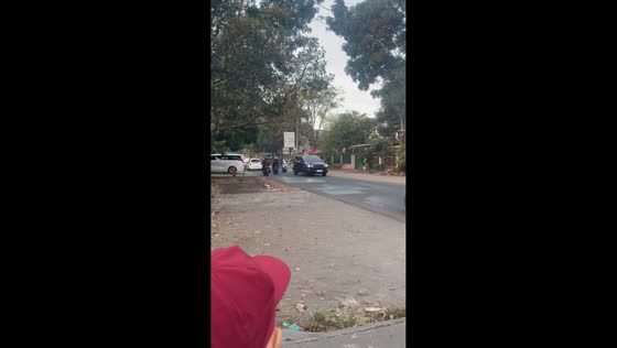 Ostrich chases motorcycle and stops near two people in Bandun, Indonesia