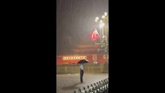 Security officer stands guard in heavy rain at Tiananmen Square in Beijing, China