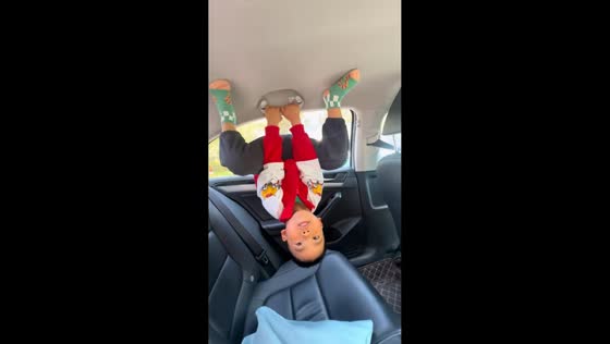 Child hangs upside down inside car using ceiling handle in Henan, China