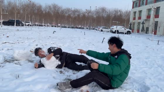 Two guys slip and laugh in the snow in Xinjiang, China