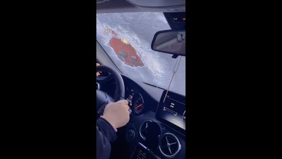 Driver carefully navigates snowy windshield in Liaoning, China