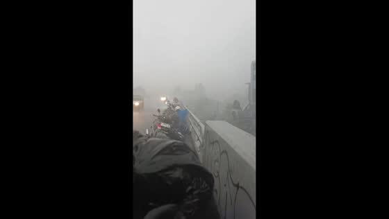 Motorcyclists take shelter amid hailstorm on flyover in Bandung, Indonesia