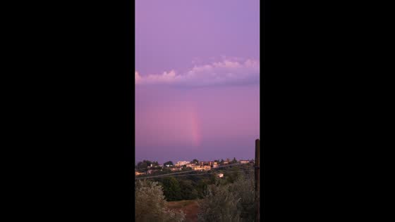 Rainbow emerges beneath stunning purple-pink sky over Amelia, Italy