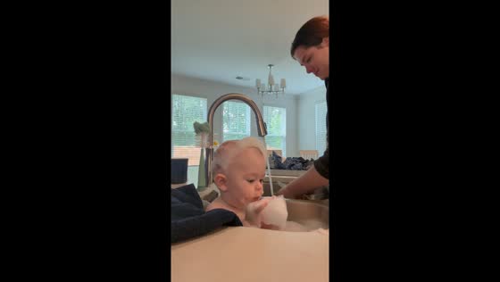 Little boy quietly plays with bubbles while sitting on sink in Greenville, South Carolina, USA