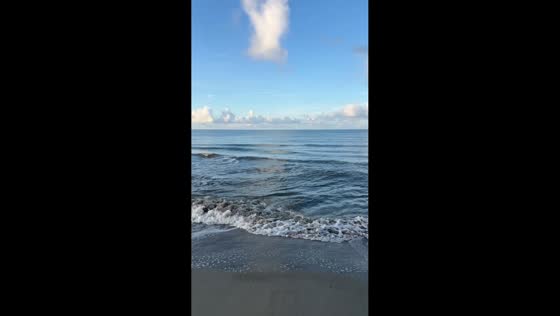Powerful surf and rough waves crash ashore on a clear day in Florida, USA