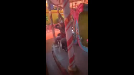 Man rides carousel while positioned under Ultraman statue in Beijing, China