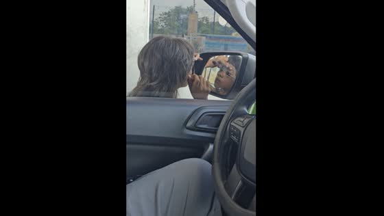Man patiently waits for girl to finish applying makeup using his car's mirror in Parañaque