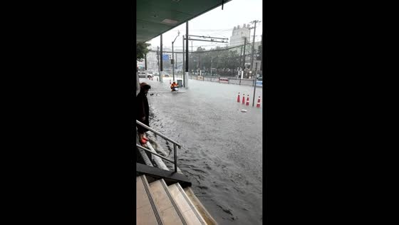 Motorcyclists navigate flooded road in Yangpu District, Shanghai, China