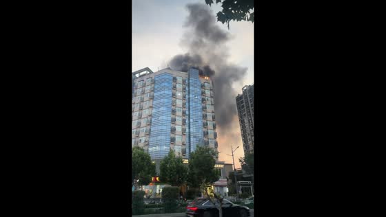 Massive fire engulfs top of building in Henan, China