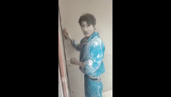 Painter plastering wall covered in white powder in Yunnan, China