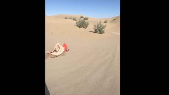 Person falls down sand dune in Varzaneh, Iran